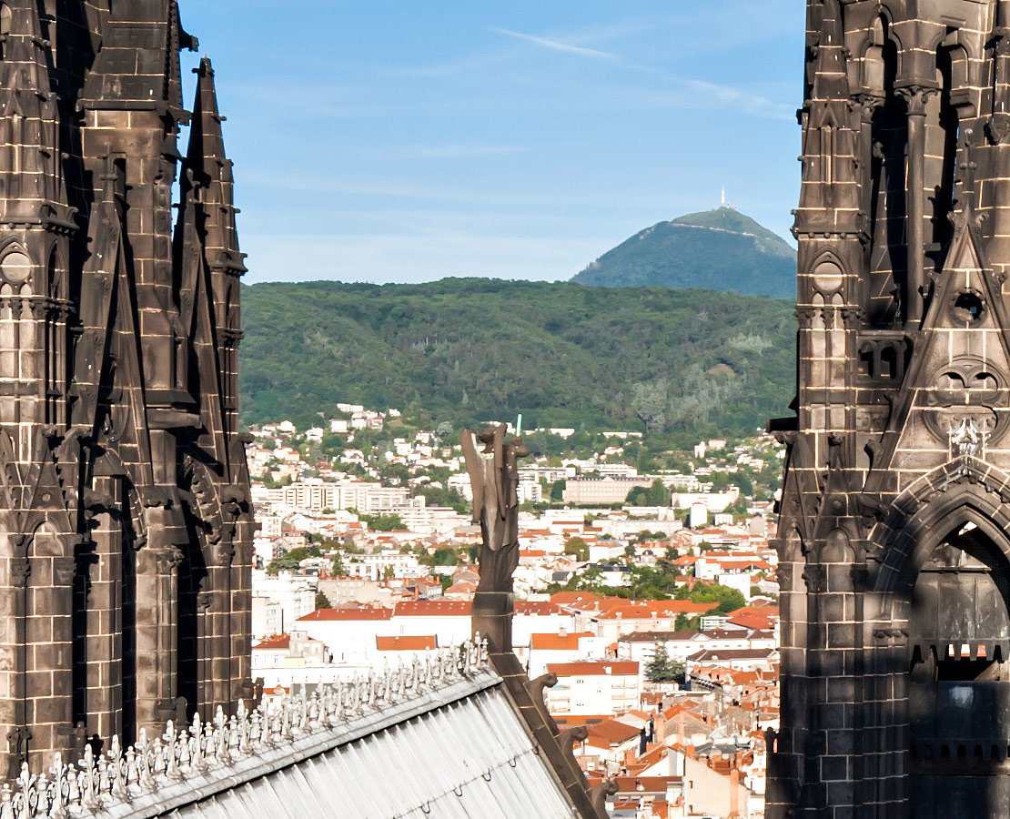 Le Puy-de-Dôme derrière les clochers de la cathédrale de Clermont-Ferrand depuis la tour de la Bayette