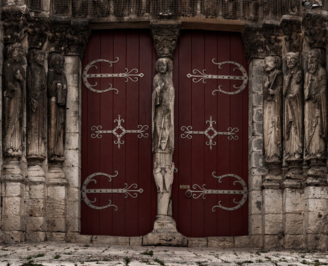 Portail de l'église Saint-Loup à Saint-Loup-de-Naud : statues-colonnes de Saint-Pierre, du Roi Salomon, de l'apôtre Saint-Paul, pentures et trumeau 