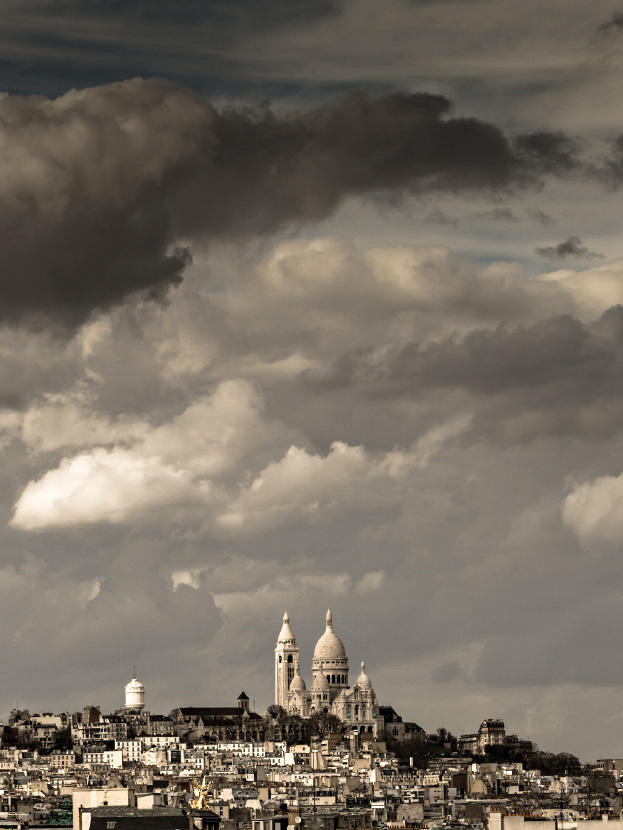 Le Sacré Coeur et la butte Montmartre sous un ciel d'orage.